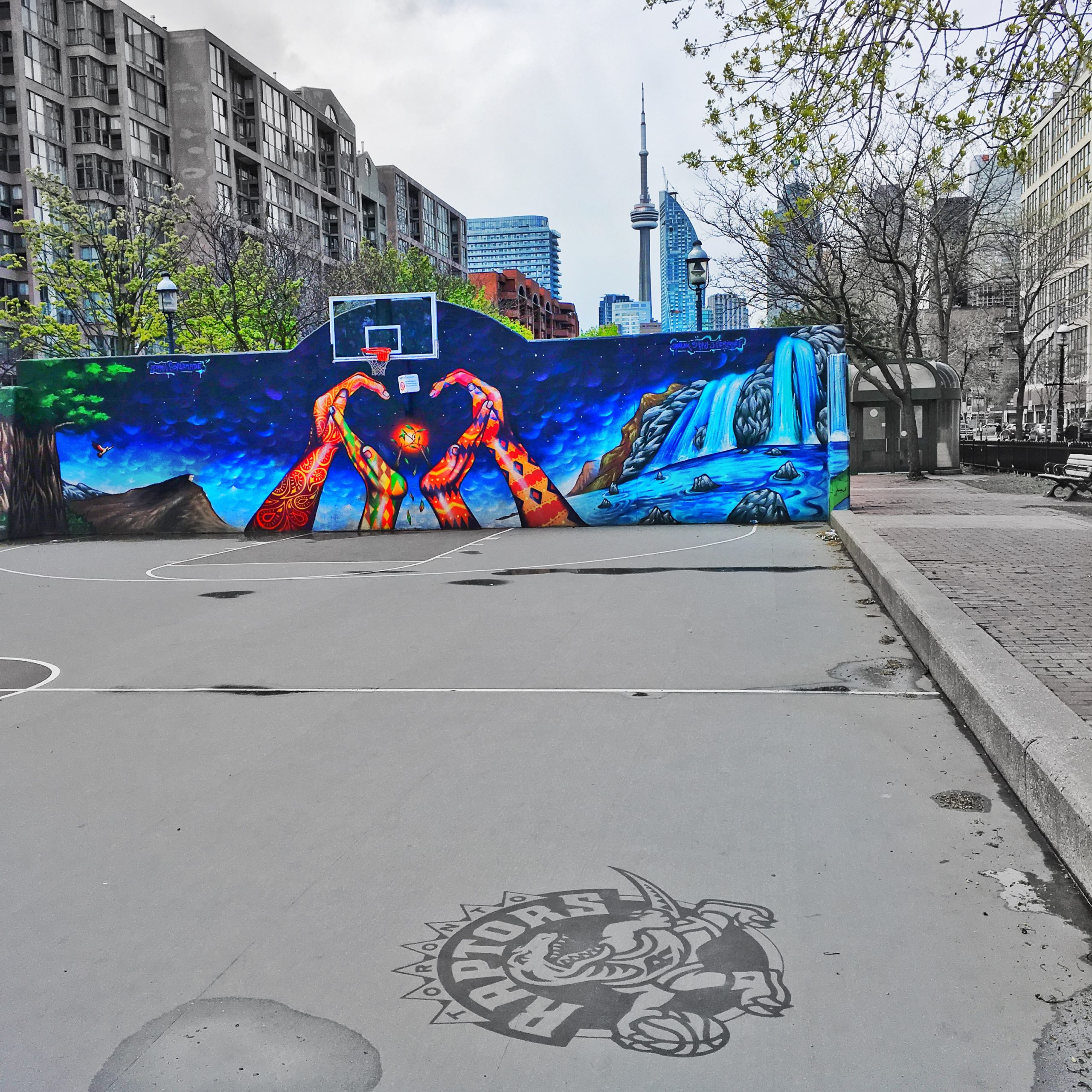 a photo of graffiti art behind a basketball court in Toronto, Canada
