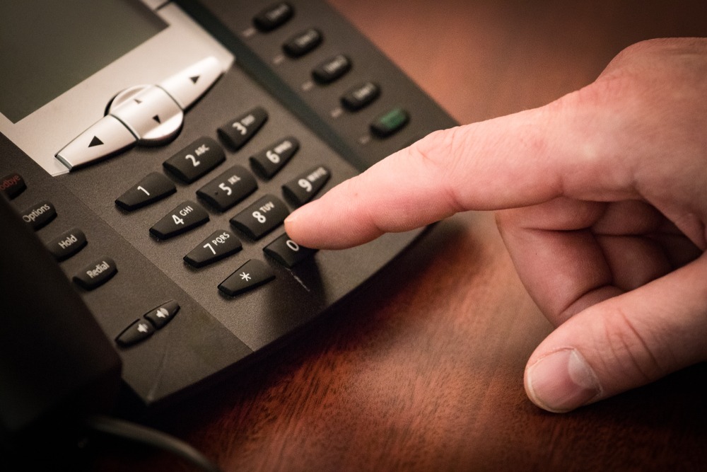 finger dialing a business phone for a cold call